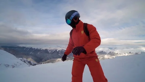 Slow motion of Close take of Male snowboarder dressed up in orange clothes rides Stockbeeldmateriaal 101787601