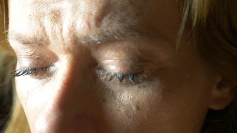 Slow motion close up: Tear comes out of an eye and streaks down the cheek. Sad Stock-Footage 87449809