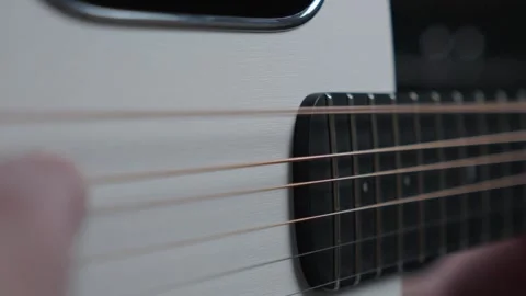 Slow Motion Close Up of Thumb Strumming Acoustic Guitar Strings Stock Footage 330121100