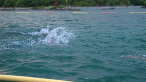 Slow motion close up of two swimmers competing in a triathlon in the sea Stock Footage 229050016