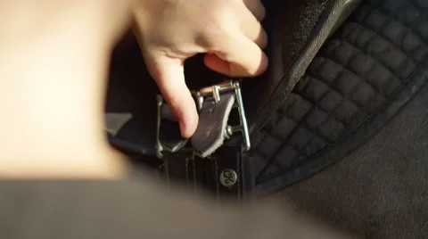 SLOW MOTION CLOSE UP: Unrecognizable person tightening a saddle on horse's back Stock Footage 66730543