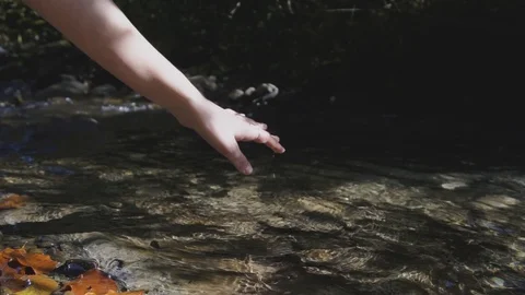 SLOW MOTION CLOSE UP: Unrecognizable young girl caressing water with soft hands  Video stock 97468649