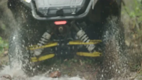 Slow motion close up of UTV wheels flinging water and mud in Colorado forest Stock Footage 234033690