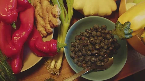 Slow motion close up of various whole fruits, herbs and vegetables on a kitchen Stock Footage 273562113