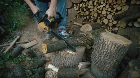 Slow motion close-up video of a man cutting a log with a chainsaw. Stock Footage 253574640