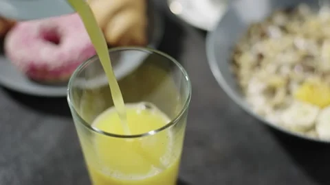 Slow motion close-up video of pouring orange juice for breakfast. Stock Footage 236538641