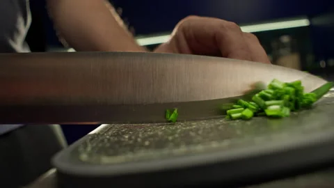 Slow motion close-up video of slicing green onions on a cutting board 스톡 동영상 220210206