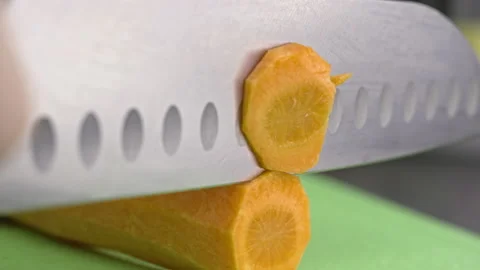 Slow motion close-up video of slicing fresh carrots for soup. Stock Footage 224959232