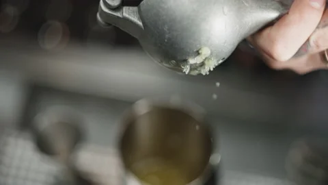 Slow motion close-up video of squeezing a lime into a glass with ice. Stock Footage 229332042