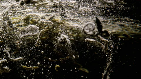 Slow motion close-up video of tea leaves being thrown into boiling water. Stock Footage 221949117