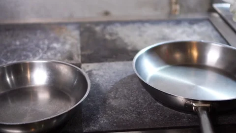 Slow motion close up view on clean steel frying pan oiled up with organic olive Stock Footage 105457246