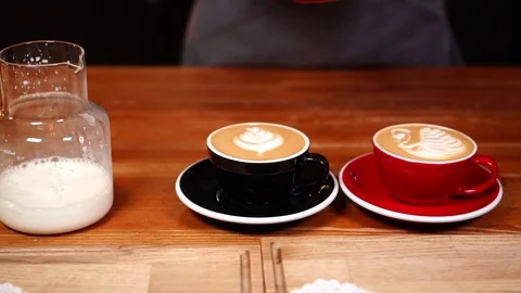 Slow motion close up view on female barista hands serving coffee cups with milk Stock Footage 104514985