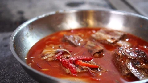 Slow motion close up view on hot tomato sauce vegetable pork ragout simmering in Stock-Footage 106813659
