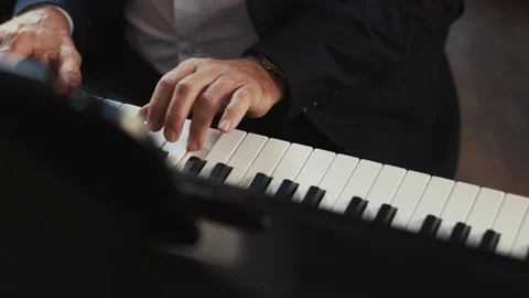 Slow motion close up view of old hands man pianist playing the fortepiano in a Stock Footage 98246989