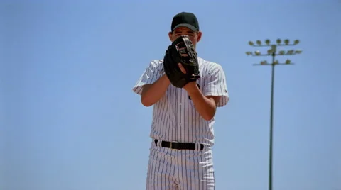 Slow-motion close view of pitcher winding up and throwing baseball Stock Footage