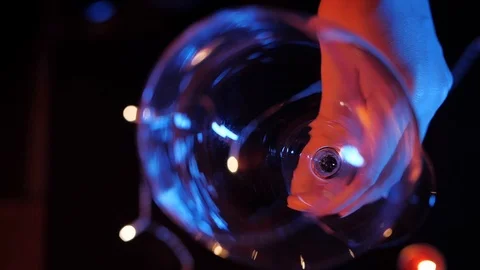 Slow motion close up view of red wine pouring by woman from bottle into goblet Stock Footage 120333535