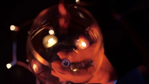 Slow motion close up view of red wine pouring by woman from bottle into goblet Stock Footage 120333574