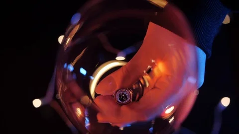 Slow motion close up view of red wine pouring by woman from bottle into goblet Stock Footage 120333621