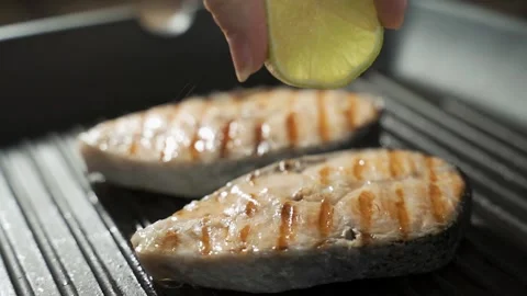 Slow motion close up view of unrecognizable hand squeezing lemon juice on Stock Footage 149025900