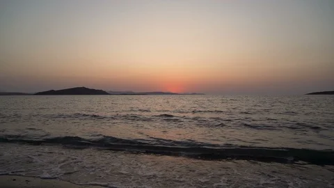Slow motion, close view of waves crashing at beach with red sunset in Greece Stock Footage 115490383