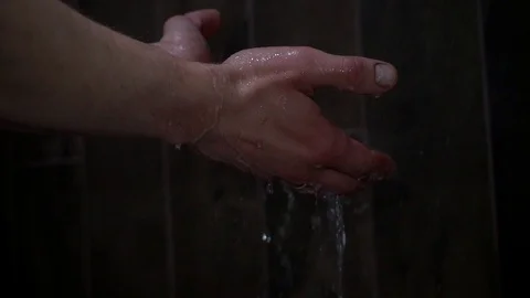 Slow motion. Close-up. Water dripping from the hands of a person who takes a sho Stock Footage 104360471