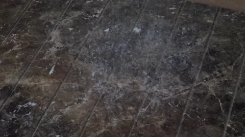 A slow-motion close-up of water drops from a shower splashing on the ground Stock Footage 310007872