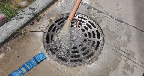 Slow-motion close-up of water flowing into storm drain. Stock Footage 340540860