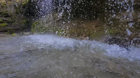 Slow motion close-up of waterfall splashing into stream, water droplets falling 库存影片 330122034