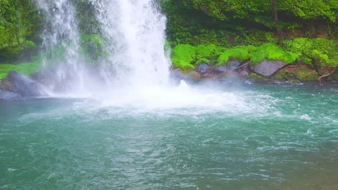 Slow motion close up of waterfall splashing into clear pool 動画素材 341806410
