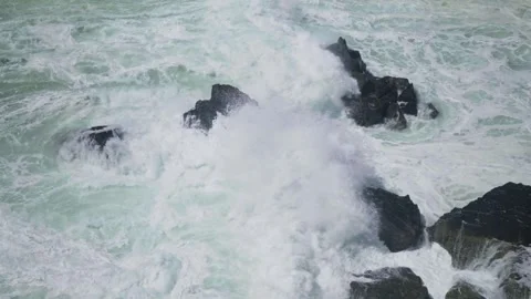 Slow Motion close up of wave breaking over rocks Stock Footage 297715646