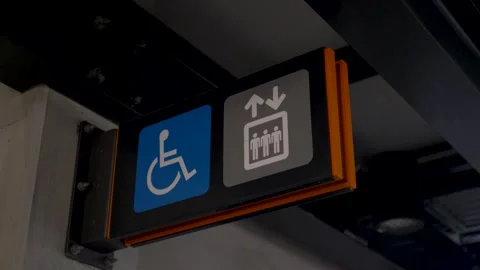 Slow motion close-up of a wheelchair accessible elevator sign symbol for a lift Stock Footage 346643999