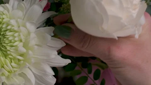Slow motion close up of white people being placed into flower arrangement Stock Footage 280123429