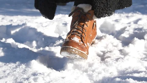 SLOW MOTION CLOSE UP winter boots walking in smooth deep snow at summer day Stock Footage 104954457