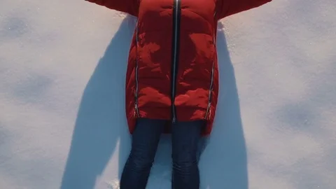 SLOW MOTION CLOSE UP: Woman making snow angels in powder Stock Footage 74355402