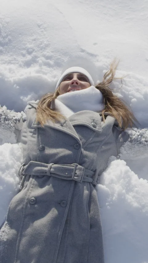 SLOW MOTION CLOSE UP: Woman making snow angels in powder Stock Footage 296757703