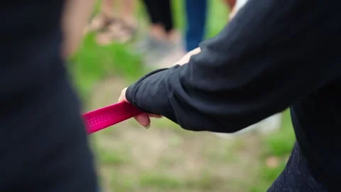 Slow-motion close-up of woman’s hand gripping red rope during outdoor activity Stock Footage 317554034