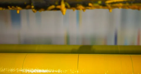 A slow motion close up of yellow coloured ink rollers and fast moving Stock Footage 156226175