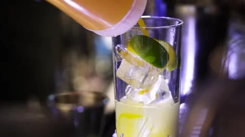 Slow Motion Close Up of Yellow Drink Being Prepared with Lime and Ice 動画素材 327482782