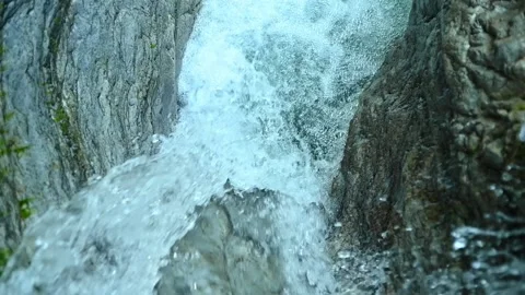Slow motion of a closeup of a beautiful waterfall between stones of a rivulet 動画素材 211492122