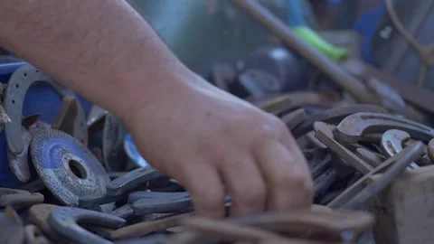 Slow motion closeup of blacksmith choosing horseshoe from the back of the truck Stock Footage 255837339