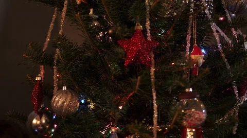 Slow motion, closeup, blond boy puts silver drop ornament on tree Stock Footage 99399722