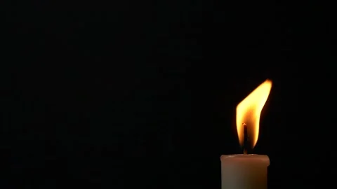 Slow motion closeup burning single candle flame isolated on black background Stockbeeldmateriaal 172465347