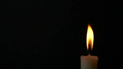 Slow motion closeup burning single candle flame isolated on black background Video stock 181796718