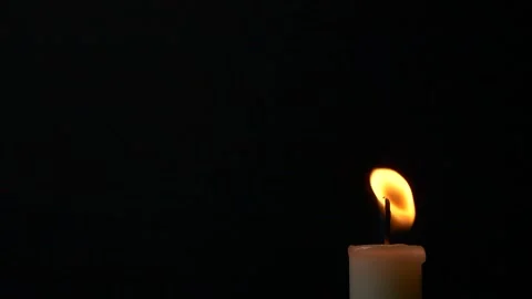 Slow motion closeup burning single candle flame isolated on black background Stockbeeldmateriaal 197587923