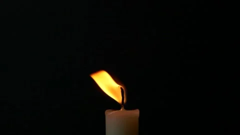 Slow motion closeup burning single candle flame isolated on black background Stock Footage 198794059
