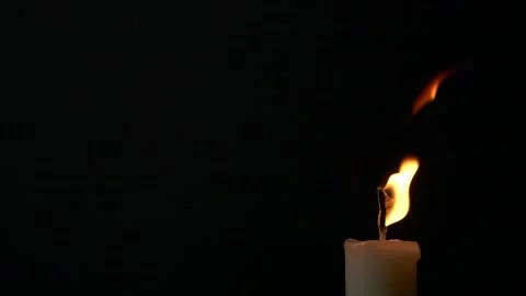 Slow motion closeup burning single candle flame isolated on black background 動画素材 200087971