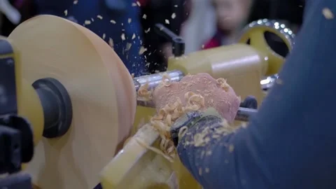 Slow motion, closeup: carpenter using chisel for shaping piece of wood on lathe Stock Footage 140910294