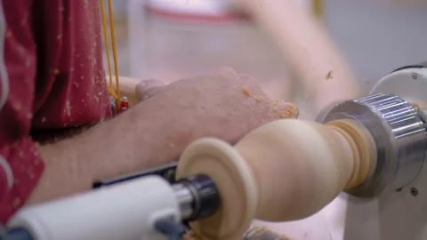 Slow motion, closeup: carpenter using chisel for shaping piece of wood on lathe Stock Footage 157420843