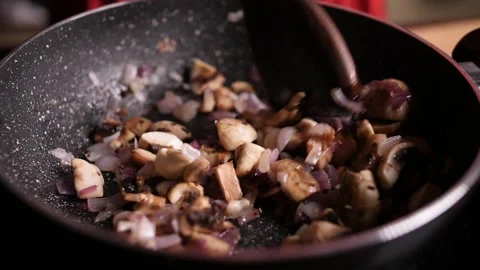 Slow motion closeup of a diced onions and mushrooms being sauteed Stock Footage 136653362