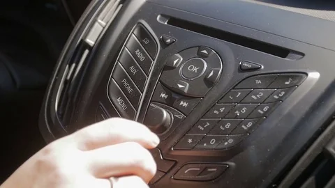 Woman Turning Up The Volume On The Car Radio Stock Photo